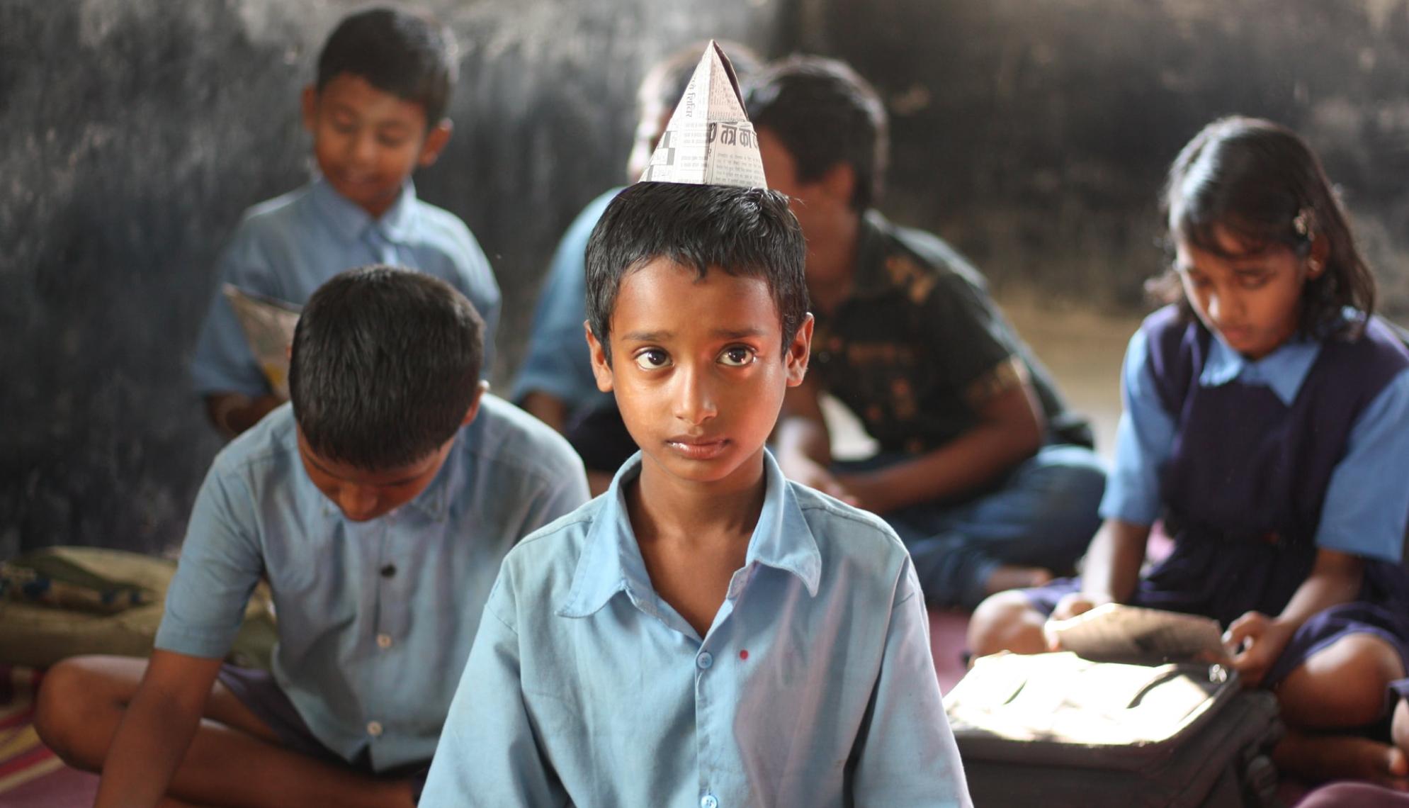 home less kid wearing a paper hat